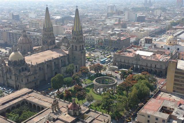 Foto aérea antigua del centro de la ciudad. Se observa una de las plazas laterales de la catedral y la rotonda de los jaliscienses ilustres. 
