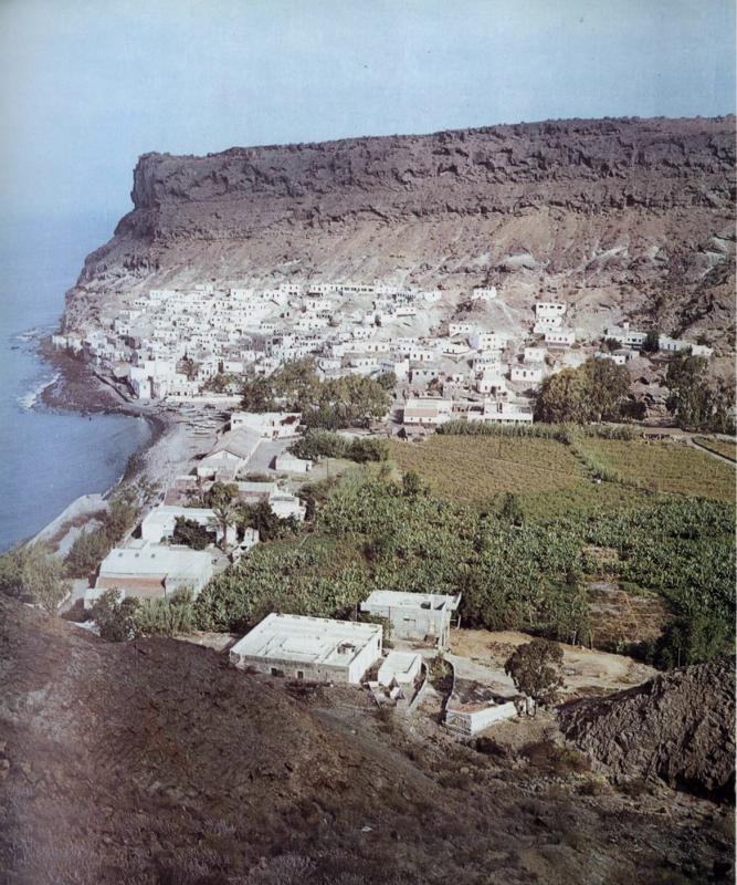 Puerto de Mogán (Gran Canaria). Las sencillas casas de pescadores, cúbicas, de cubierta plana, con una puerta central y dos ventanas laterales como únicos elementos compositivos, se arraciman en las laderas, reservando una vez más el lecho del barranco a los cultivos.